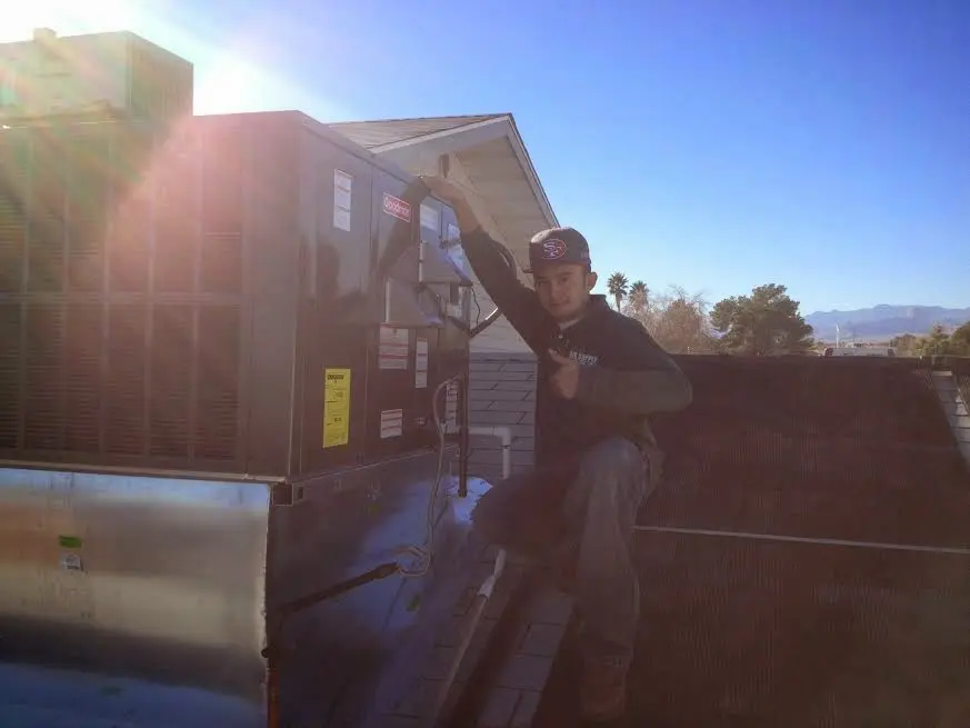 HVAC technician performing Heat Pump Repair on a rooftop unit in Greenwich