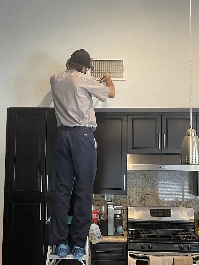 Technician inspecting an air vent during HVAC service in Greenwich